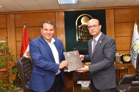 باحث يهدى رئيس جامعة أسيوط نسخة من دراسته العلمية بشأن الإعلام الرسمي للجامعة